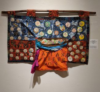 Leanora E. Mims • <em>Say Her Name: Atatiana Jefferson, Bullet Proof Soul</em> • Mixed media quilted wall hanging • 23“×19½“ • $950.00<a class="purchase" href="https://state-of-the-art-gallery.square.site/product/leanora-e-mims-say-her-name-atiana-jefferson-bullet-proof-soul/383" target="_blank">Buy</a>
