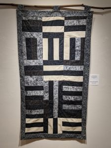 Leanora E. Mims • <em>Say Her Name: Sunset, Brionna Taylor </em> • Gees Bend quilting pattern • 23½“×43“ • $850.00<a class="purchase" href="https://state-of-the-art-gallery.square.site/product/leanora-e-mims-sunset-quilted-wall-hanging/386" target="_blank">Buy</a>